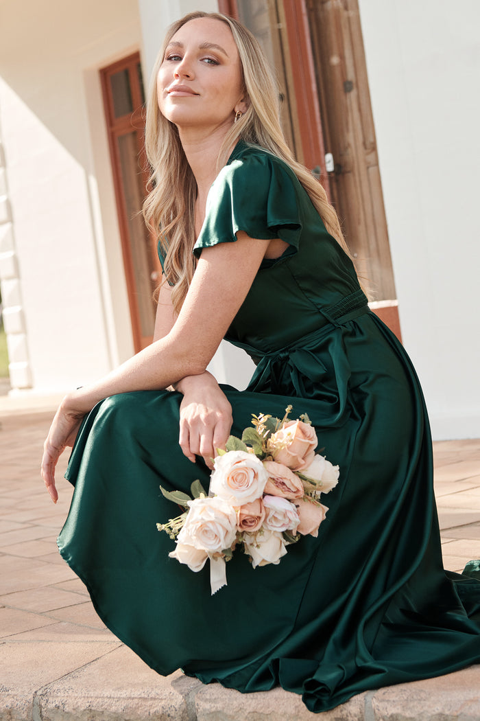 Loulou Maxi Dress In Emerald Satin campaign closeup sitting