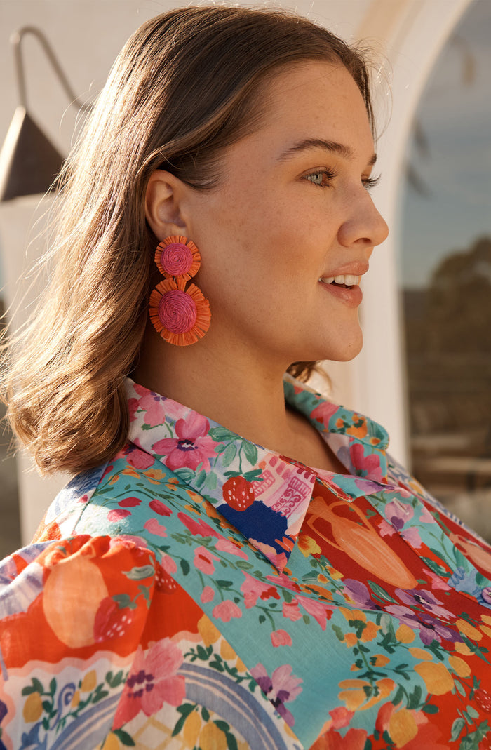 Poppy Earrings in Fuchsia and Tangerine Raffia campaign on model side