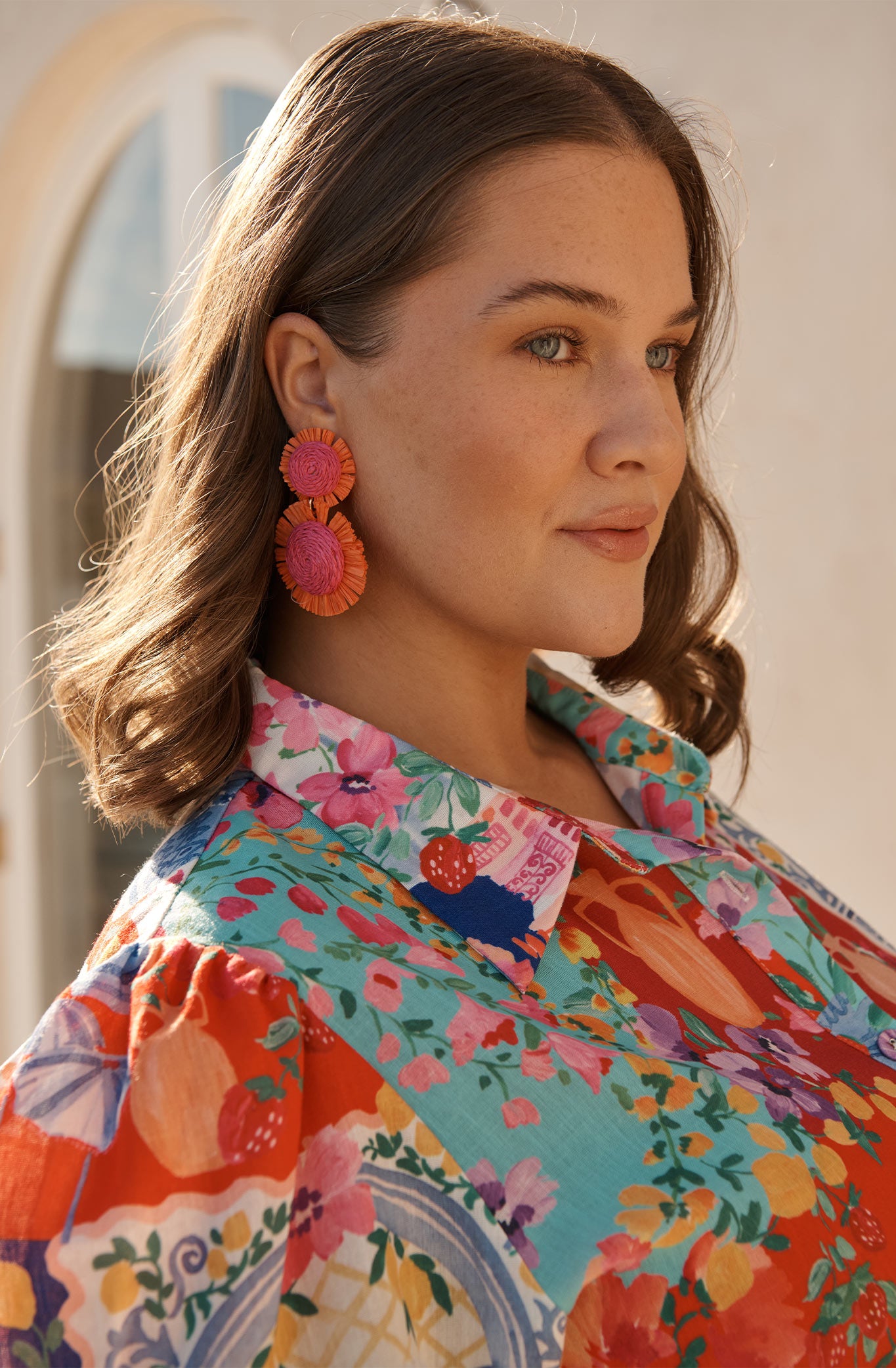 Poppy Earrings in Fuchsia and Tangerine Raffia campaign on model side