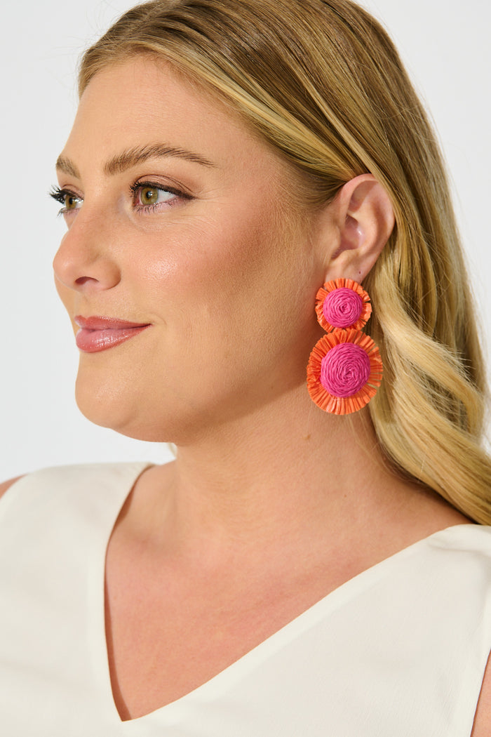 Poppy Earrings in Fuchsia and Tangerine Raffia on model side