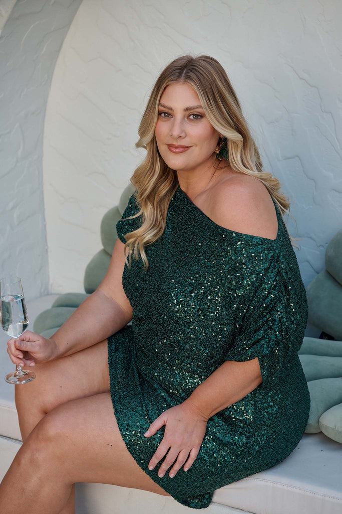 Shayla Off Shoulder Dress in Emerald Sequin campaign sitting
