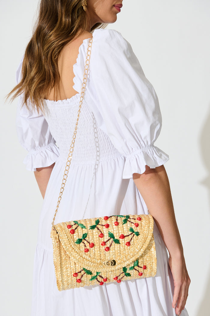 Clara Cherry Embroidered Straw Crossbody Bag in Natural on model sling