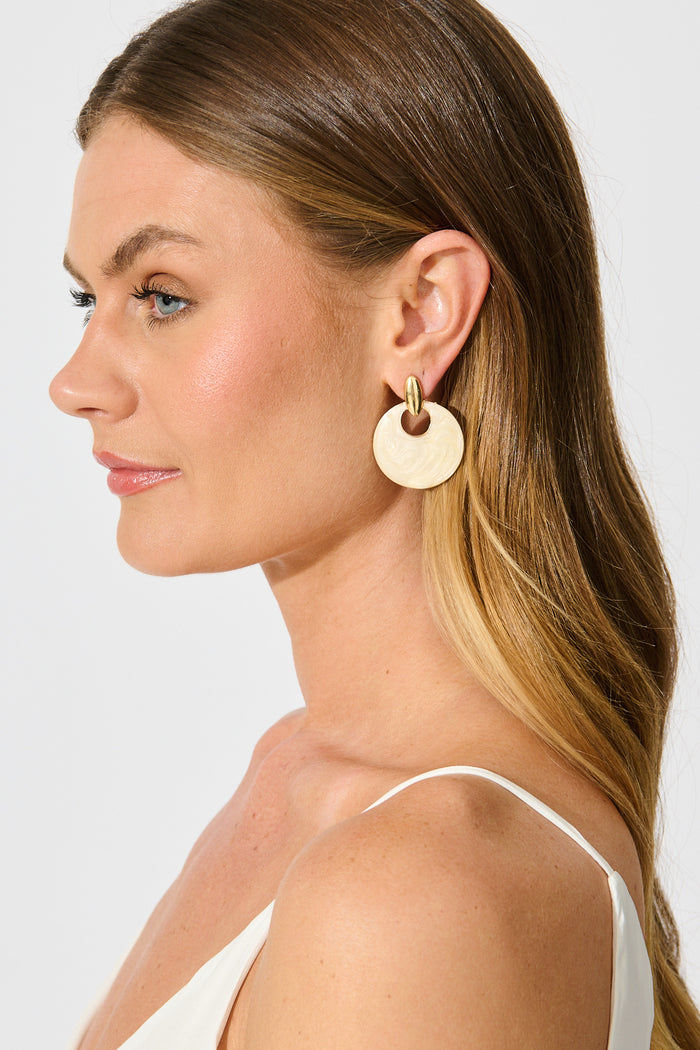 Nova Resin Drop Earrings in Gold with Cream Swirl on model side