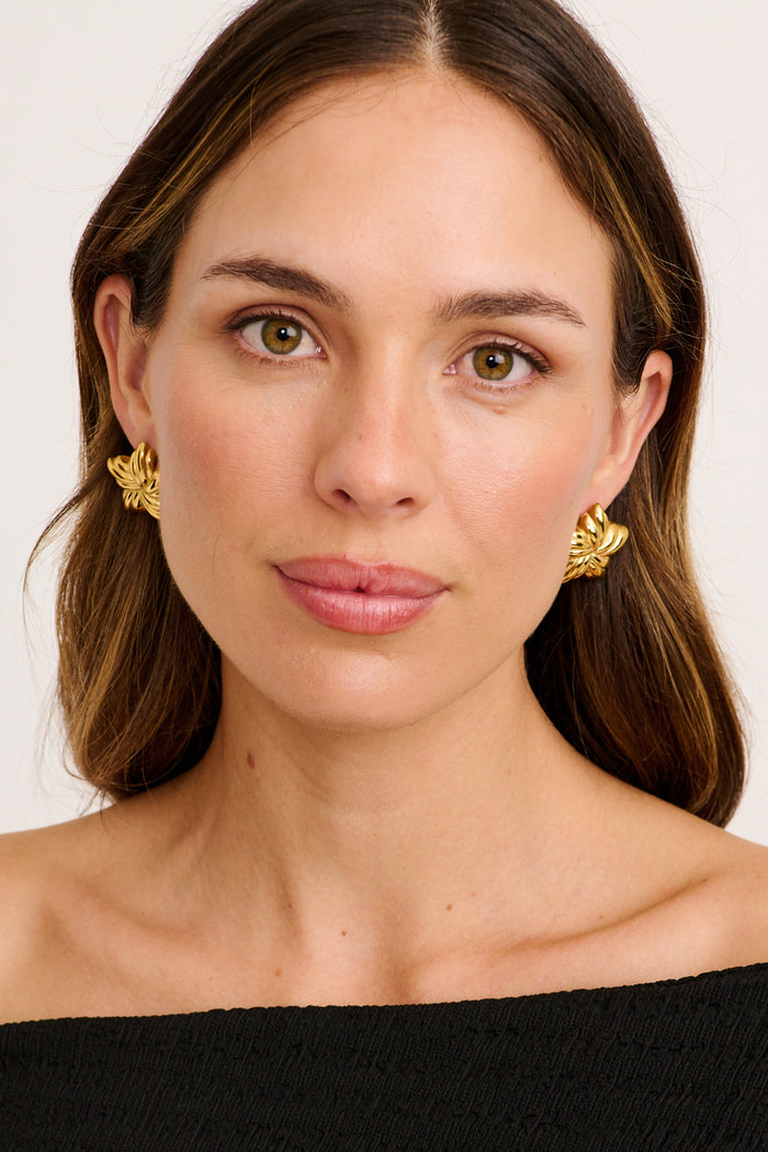 Veda Floral Stud Earrings in Textured Gold on model front