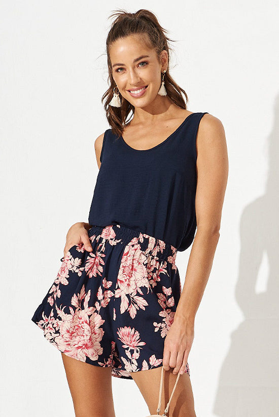 Women in a Navy Tank Top tucked into navy and pink floral shorts.